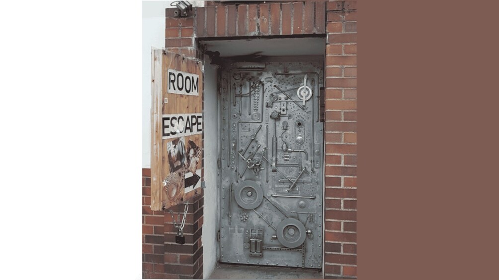A metal door with a 'ROOM ESCAPE' sign and a complex lock mechanism. 3