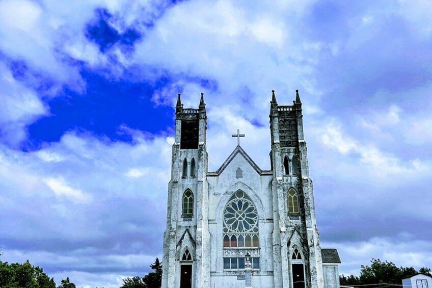 A Gothic-style church with two towers, a large rose window, and a cross on the facade. 5