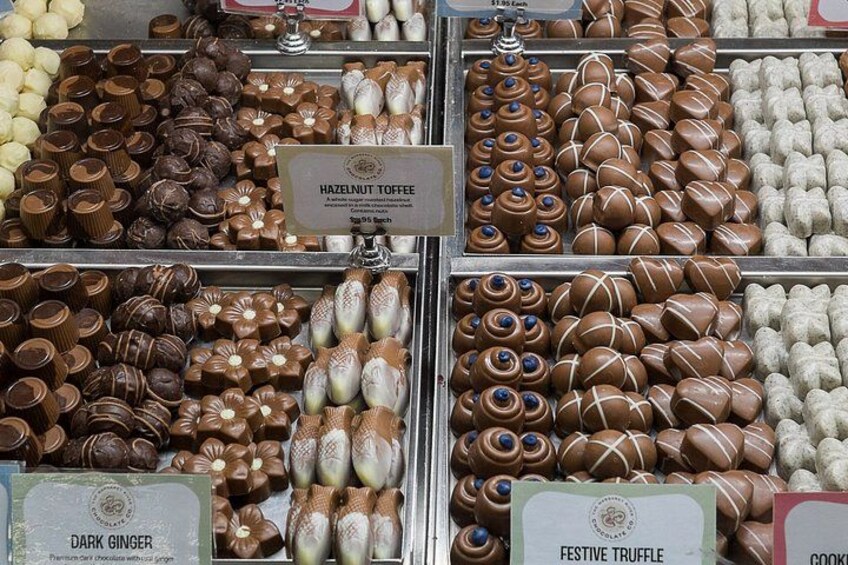 A variety of chocolates in glass containers with labels such as 'Hazelnut Toffee' and 'Festive Truffle.' 3