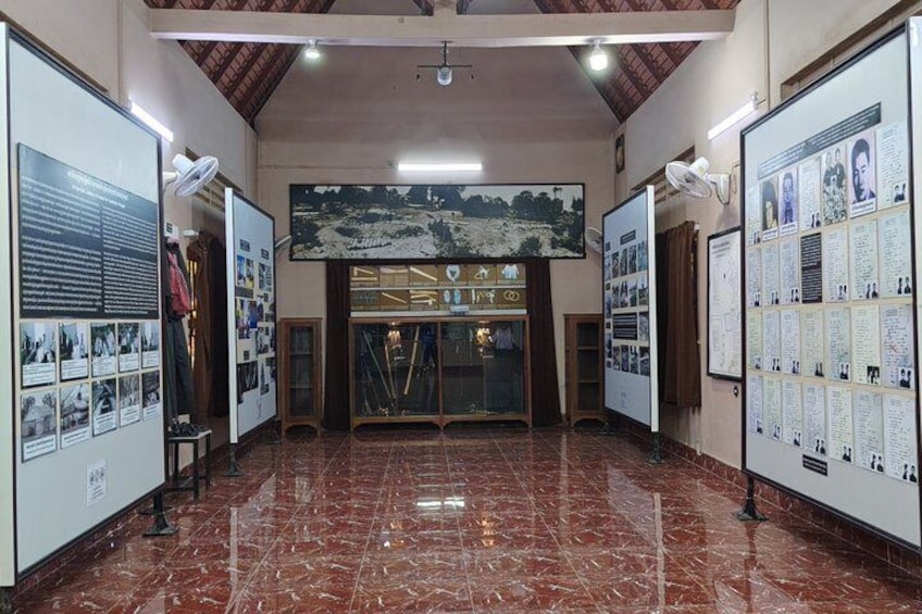 A museum interior with marble floors, informational displays, and a central entrance. 3