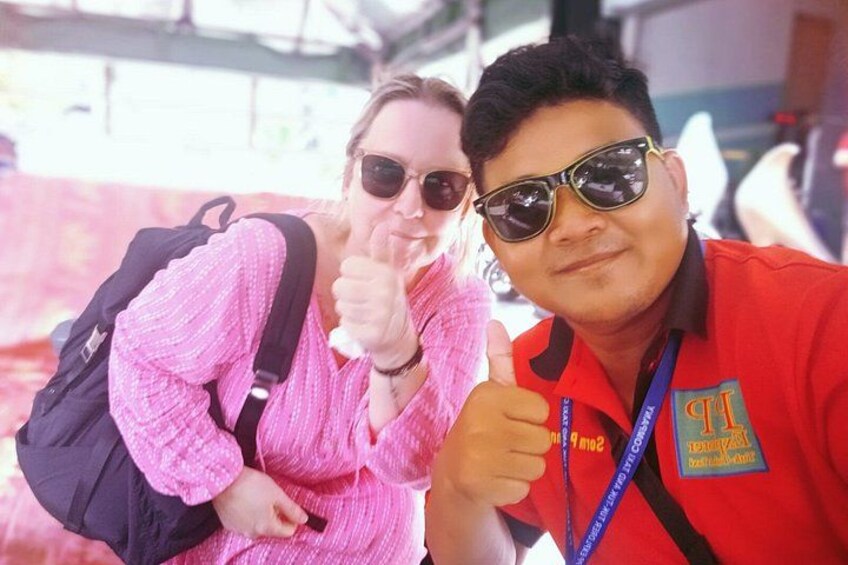 A person in a pink sweater and sunglasses giving a thumbs-up. 2