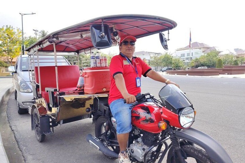 A man on a red motorcycle with a trailer, parked on a street. 3