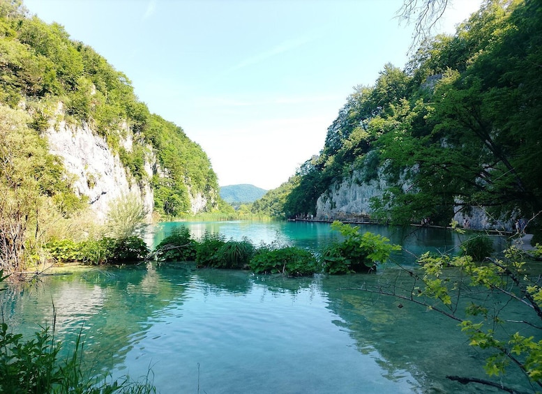A calm river surrounded by lush greenery and rocky cliffs. 5
