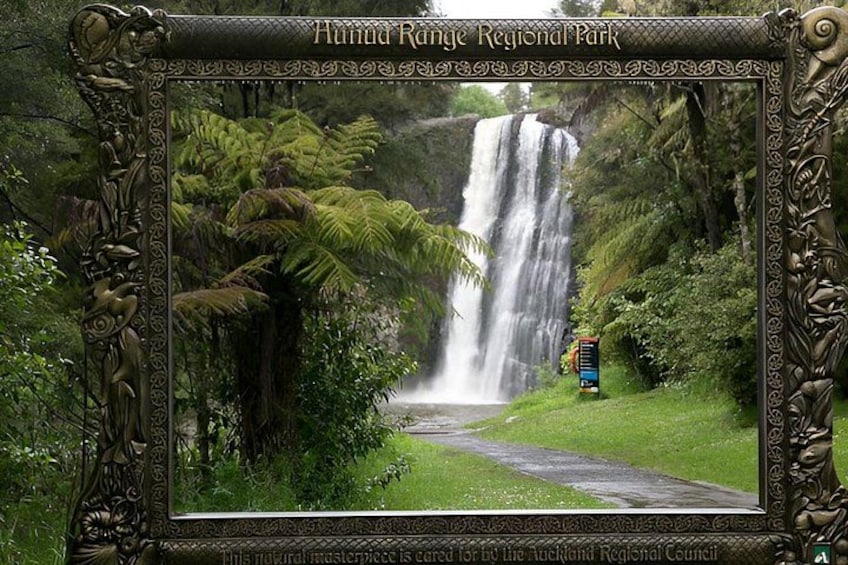 A waterfall in a lush forest, surrounded by greenery and a path. 1