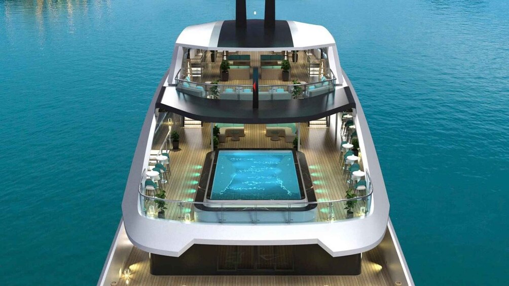 A modern cruise ship with a pool and outdoor seating on the upper deck. 1