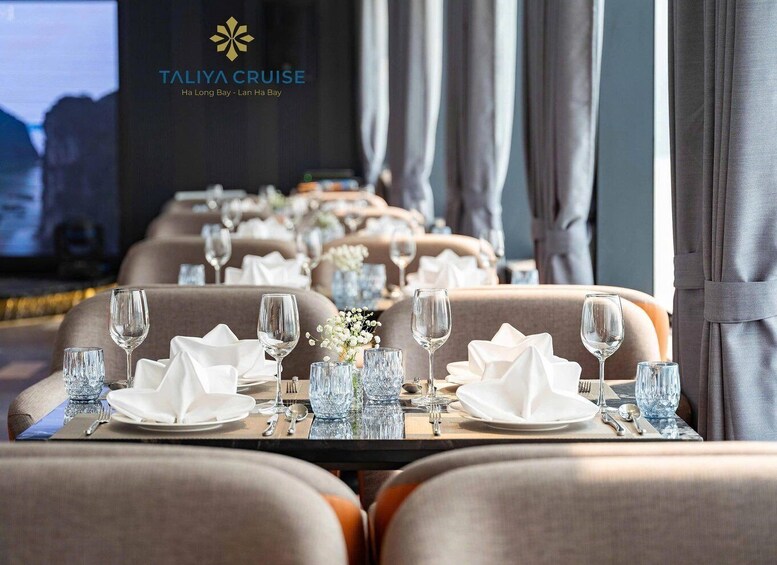 A restaurant dining area with tables set for a meal, featuring a logo for TAIYA CRUISE in the background. 4
