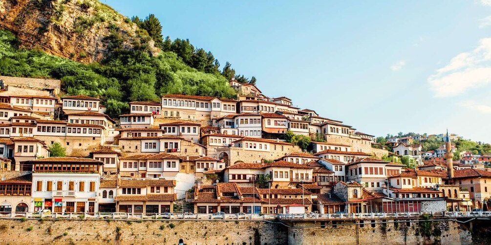 A hillside settlement with terraced buildings, a prominent church, and a clear sky. 5