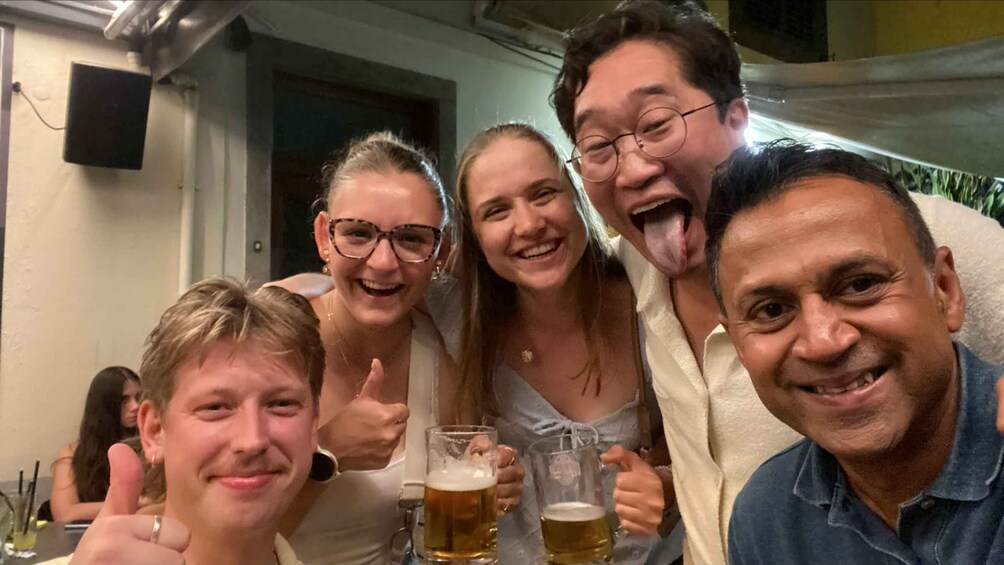 A group of people in a bar holding beer glasses. 5