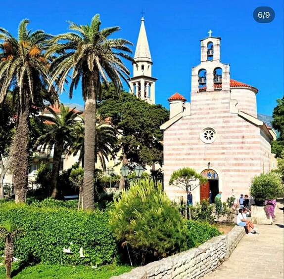 A church with a bell tower and palm trees in the foreground. 4
