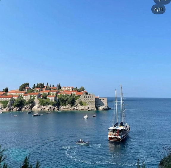 A coastal town with historic buildings, a sailboat, and several smaller boats on the water. 5