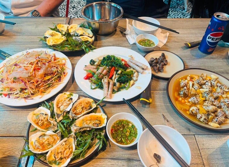 A variety of dishes on a wooden table, including seafood, vegetables, and a can of Pepsi. 4