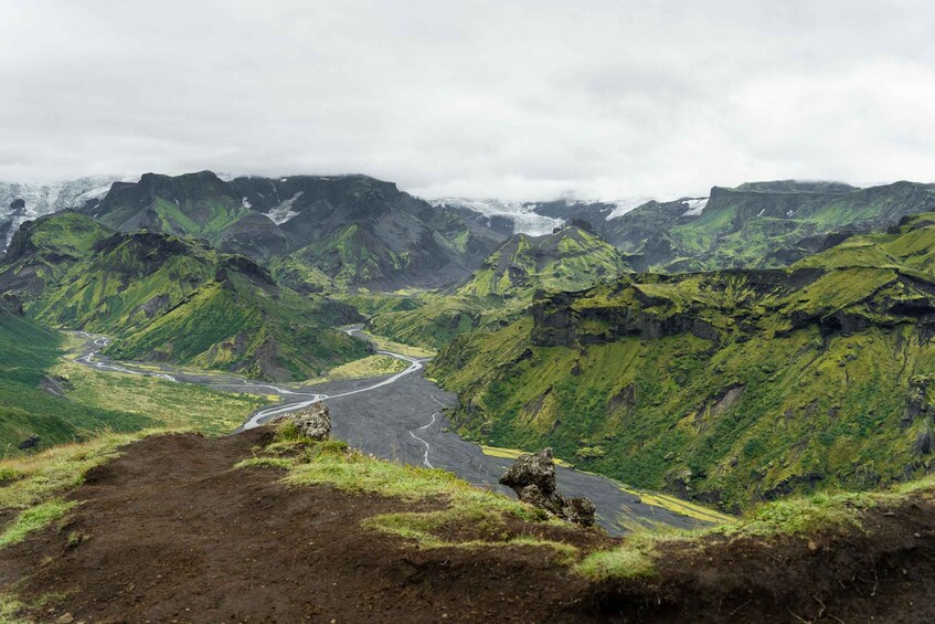 A mountainous landscape with a winding road and a river. 4