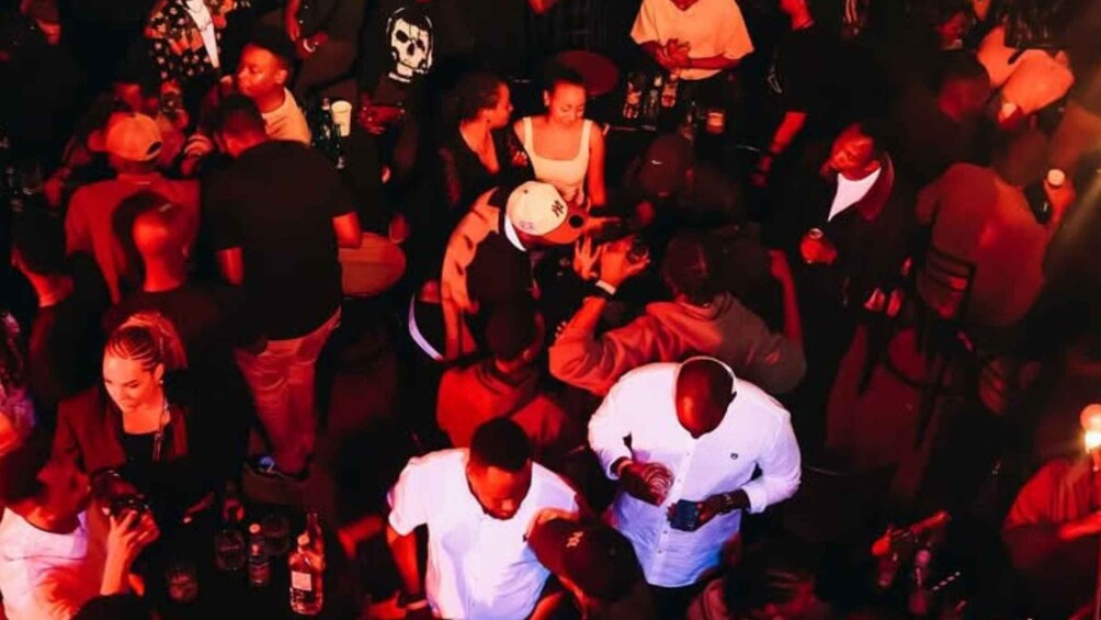 A crowded indoor event with people standing and interacting. 2