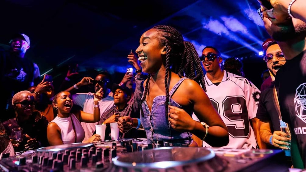 A DJ performing at a club with a crowd enjoying the music. 1