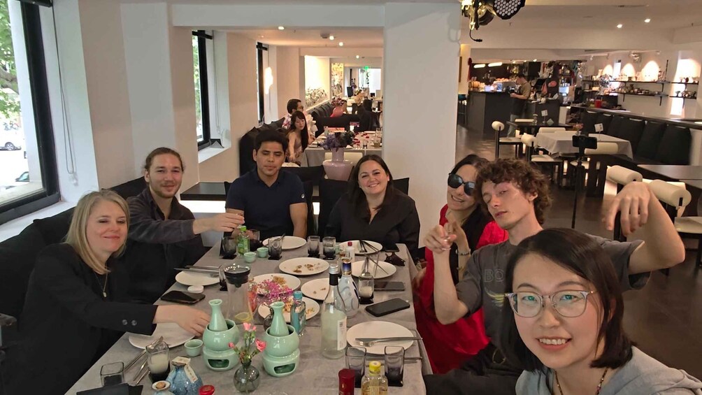 A group of people dining at a restaurant with a bar in the background. 1