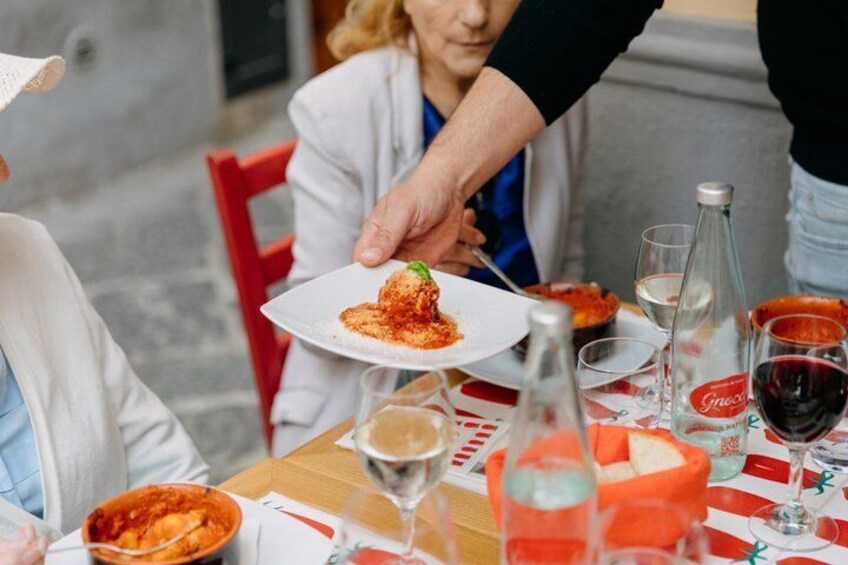 A dining table with a plate of food, wine glasses, and a bottle. 2