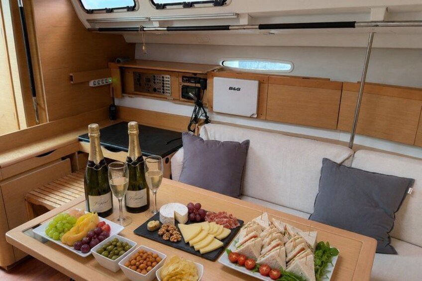 A yacht interior with a dining table set with food and drinks. 2