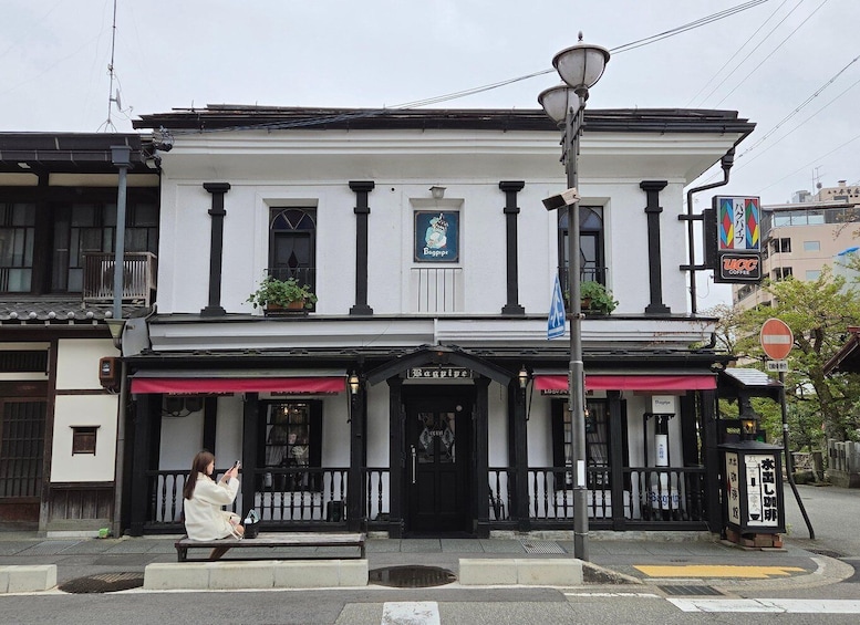 A traditional building with a black and white facade, a sign for 'Bagpipe,' and a 'UCC Coffee' sign. 3