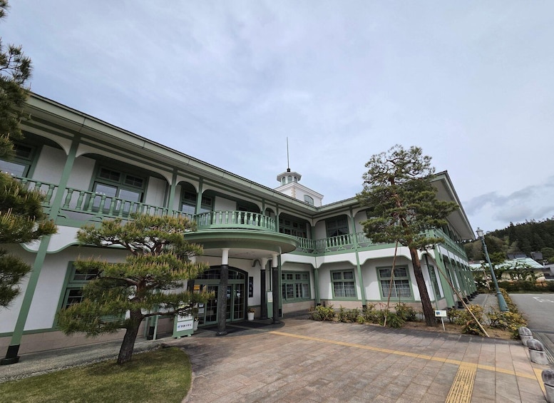 A traditional building with a green and white facade, a central entrance, and a small tower. 2
