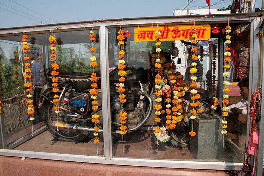 A motorcycle inside a glass enclosure decorated with orange and yellow flowers. 4