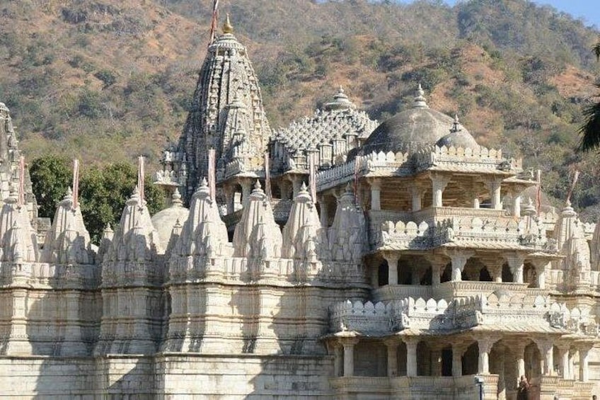 A temple with multiple spires and intricate carvings, set against a hilly backdrop. 3