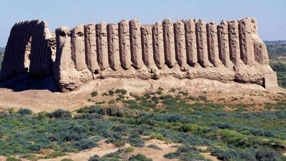 A large, ancient stone structure with a series of vertical columns and a flat top. 3