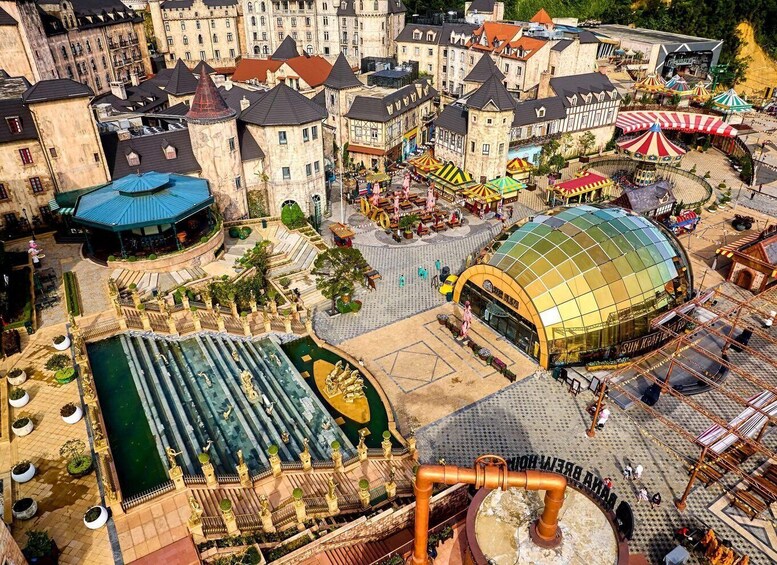 A theme park with medieval-style buildings, a large water feature, and a covered area with a dome. 5