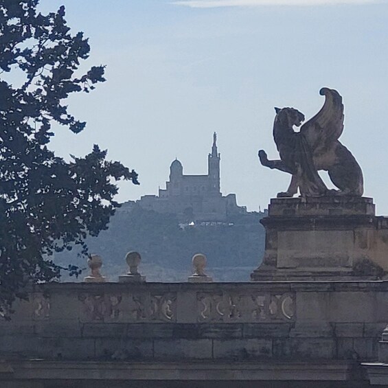 A stone lion statue on a pedestal, a bridge with decorative balustrades, and a distant building with a prominent tower. 1