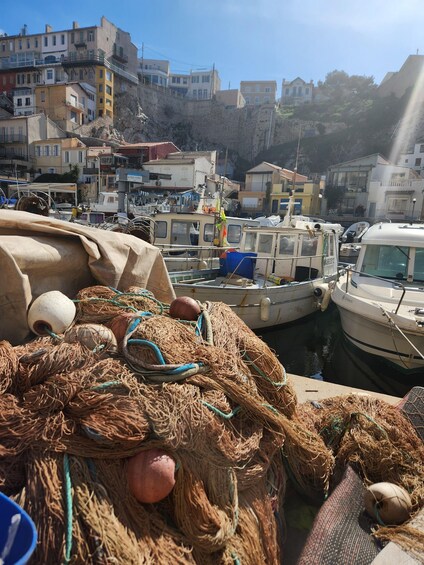 A harbor with boats, fishing nets, and buildings along the waterfront. 3
