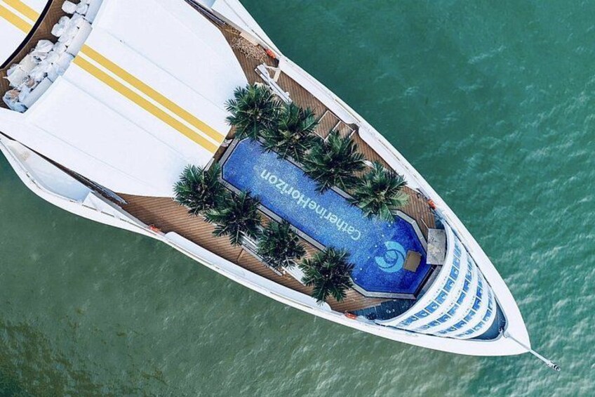 A yacht with a blue deck area, palm trees, and a wake. 3