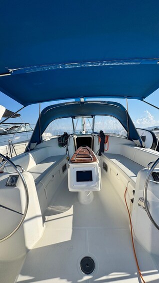 A boat's deck with a blue canopy, a wooden bench, and a control panel. 5