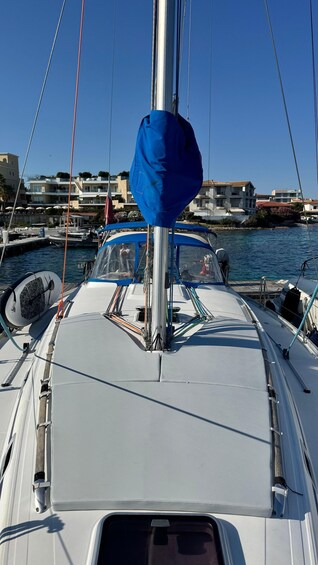 A sailboat docked at a marina with buildings in the background. 2