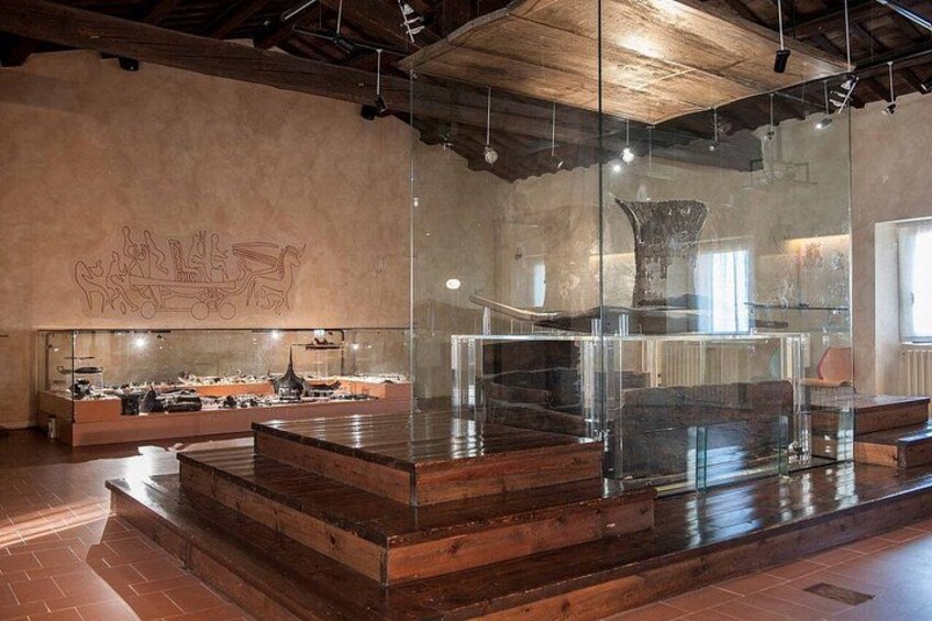 A modern interior with wooden flooring, glass display cases, and a large abstract wall art piece. 2
