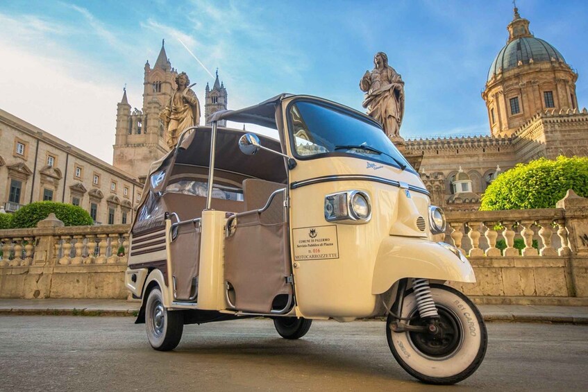 A vintage car parked in front of a historic building with statues and domes. 4