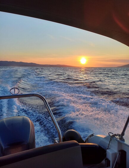 A boat's interior with a view of the ocean and a sunset. 2