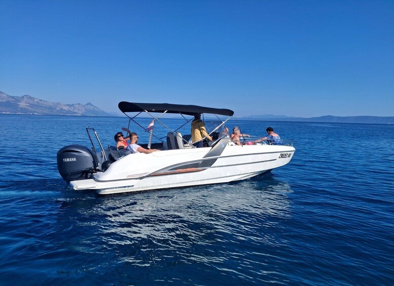 A white motorboat with a Yamaha engine on the water. 2
