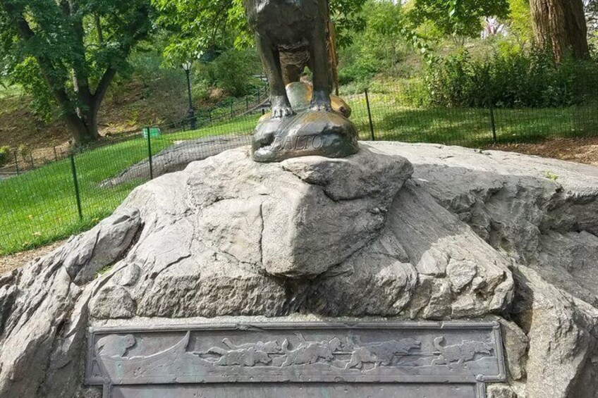 A large rock with a lion statue on top and an engraved plaque. 2