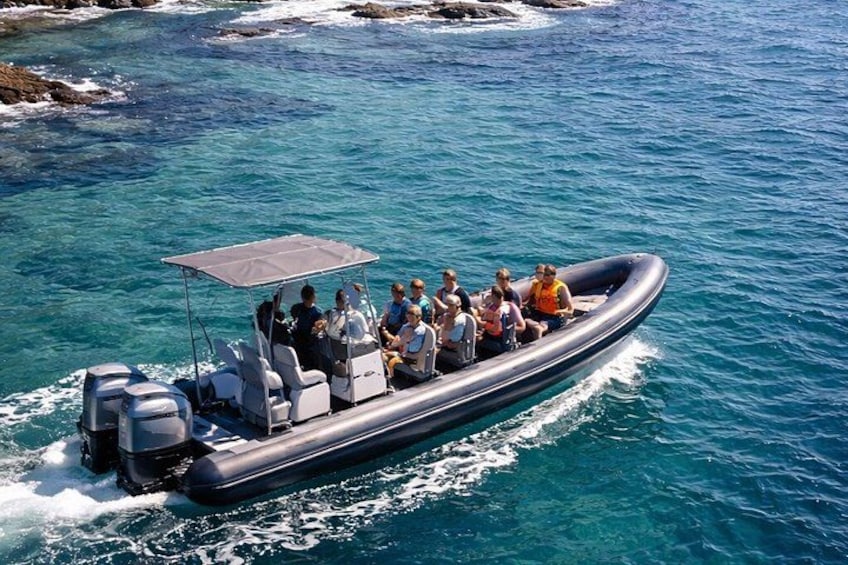 A motorboat with passengers on a clear blue sea. 2