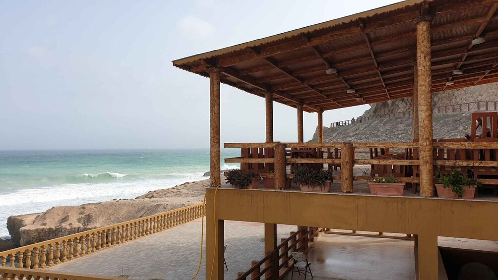 A wooden beach structure with a railing overlooking the ocean. 2