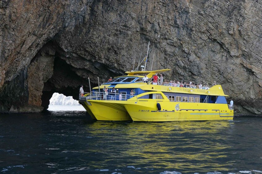 A yellow boat named 'Subaquatic Vision' docked near a rocky cave with an iceberg in the background. 3