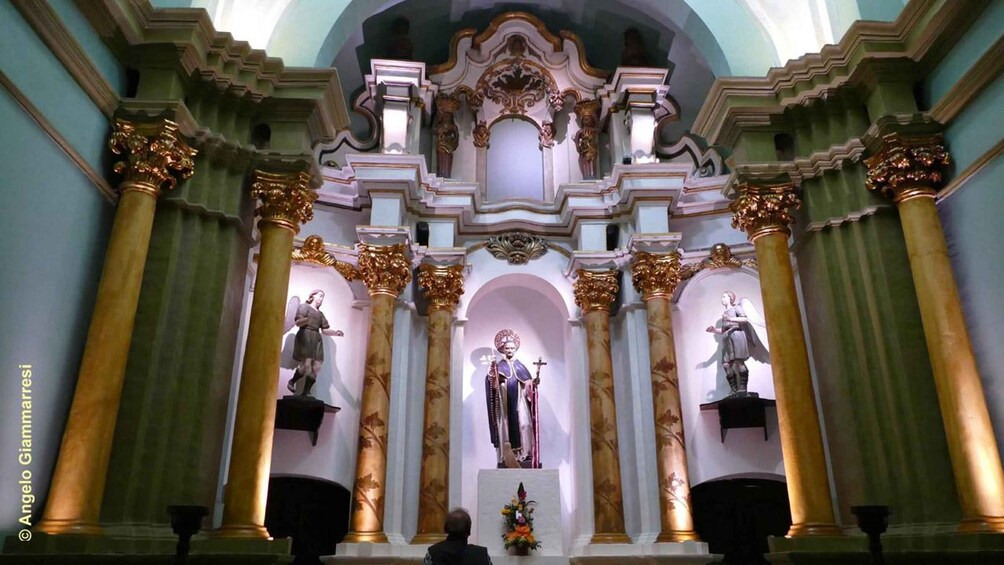 An ornate church interior with statues and a central figure. 5