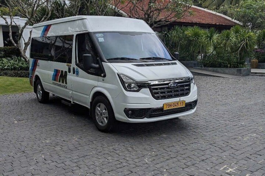 A white van with blue and red stripes parked on a cobblestone surface. 2