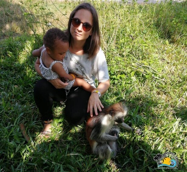 A person sitting on grass with a small dog. 4