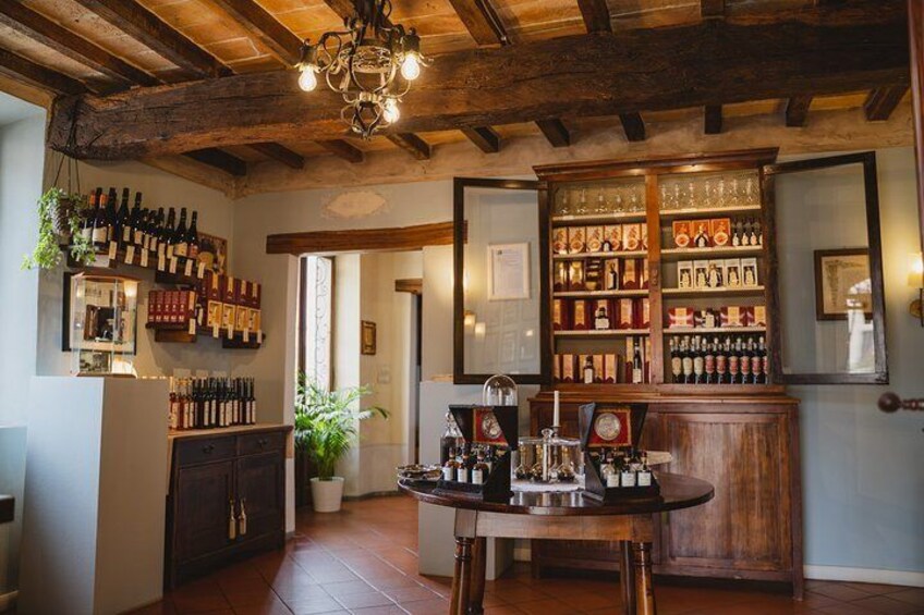 A rustic bar with wooden beams, a chandelier, and shelves of bottles. 5