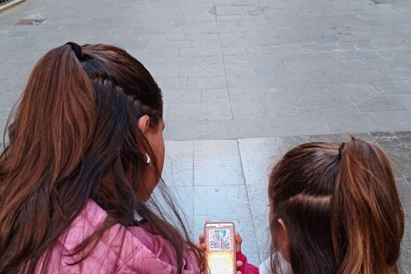 Two individuals with ponytails, one holding a smartphone. 2