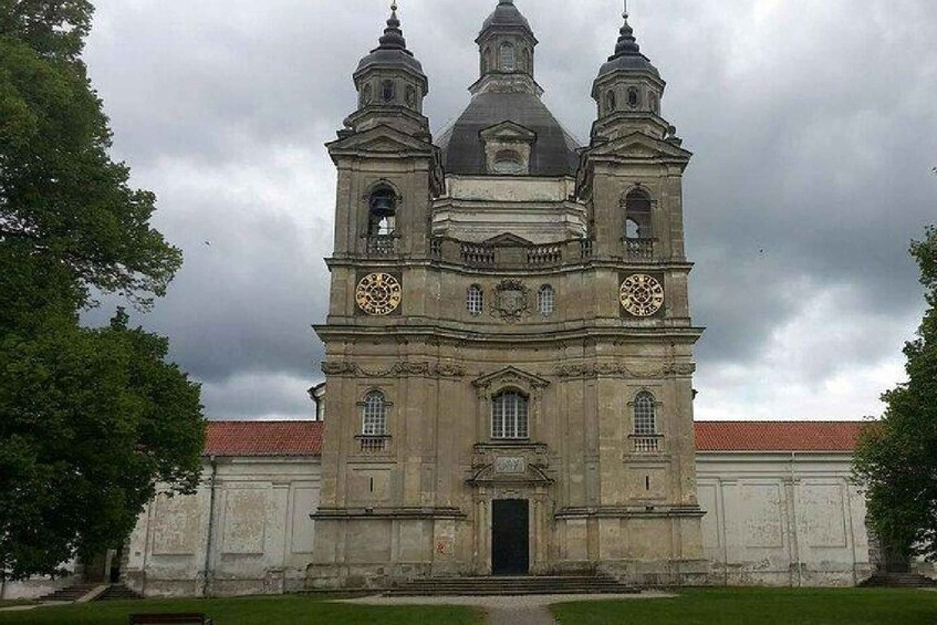 A historic building with a central dome and two bell towers, surrounded by a well-maintained lawn. 2