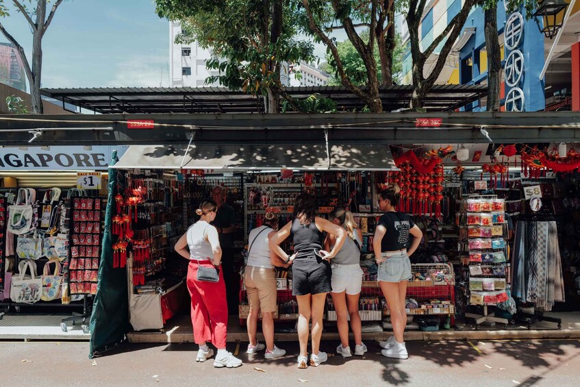 A street market with various stalls selling items like bags and accessories. 2