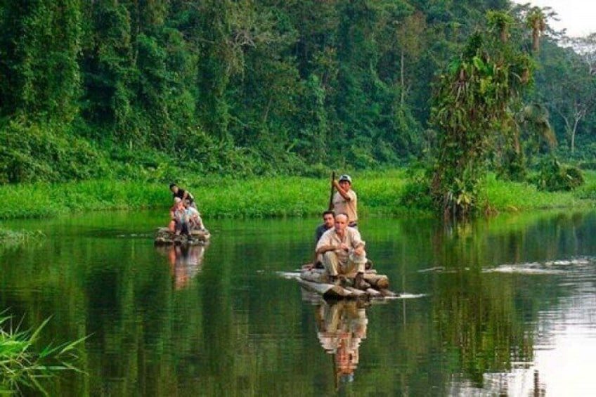 People in a boat on a calm river surrounded by lush greenery. 2