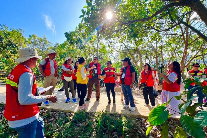 A group of people in red vests gathered outdoors, possibly for an educational or environmental activity. 4