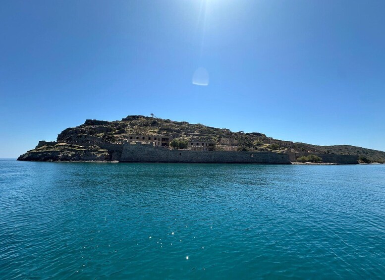 A coastal island with historical buildings and a clear blue sea. 4